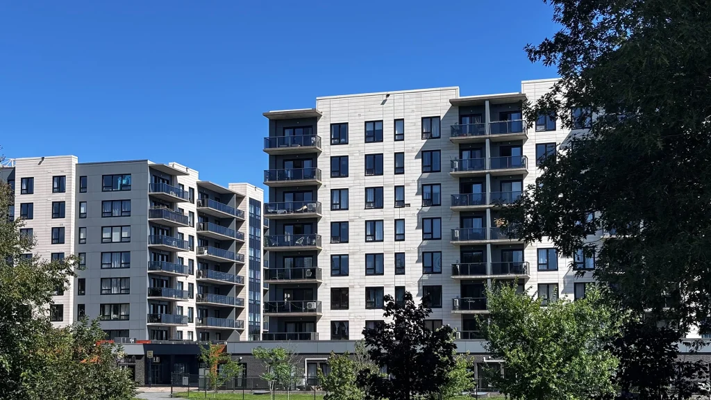 The Boss Plaza Exterior view of Boss Plaza in Fairview, Halifax, Nova Scotia, featuring modern multi-storey residential buildings with light-coloured facades, black-framed windows, glass balconies, and surrounding greenery.